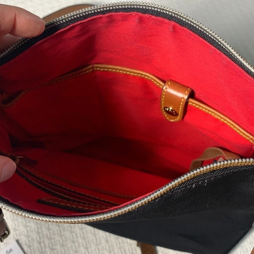 Dooney & Bourke black nylon crossbody bag with brown leather strap and accents